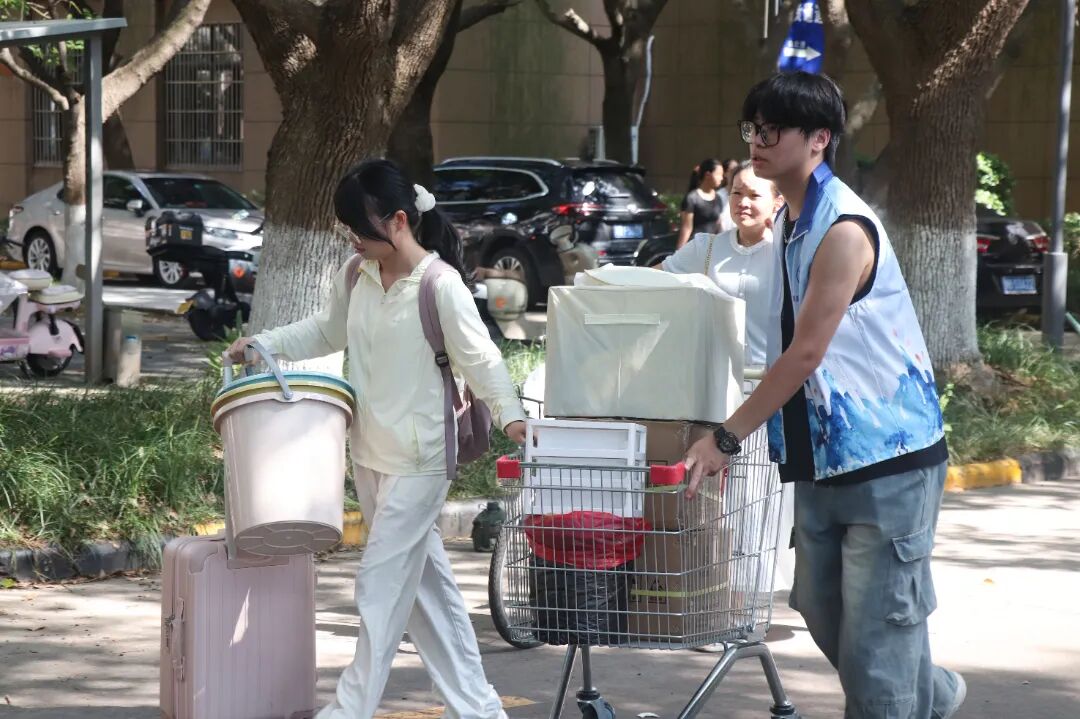 图为:志愿者和同学一起搬行李.JPG